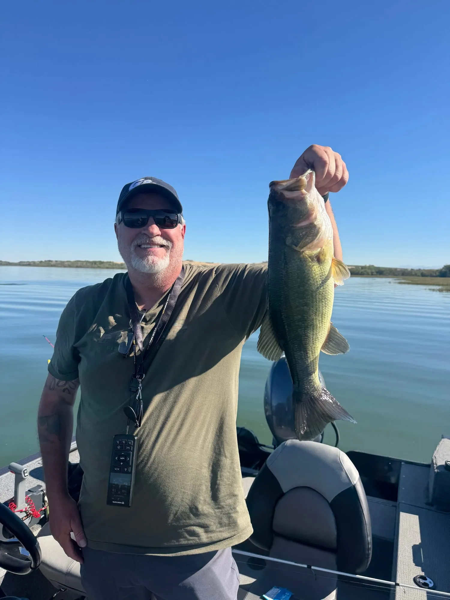 A largemouth bass held up in the boat
