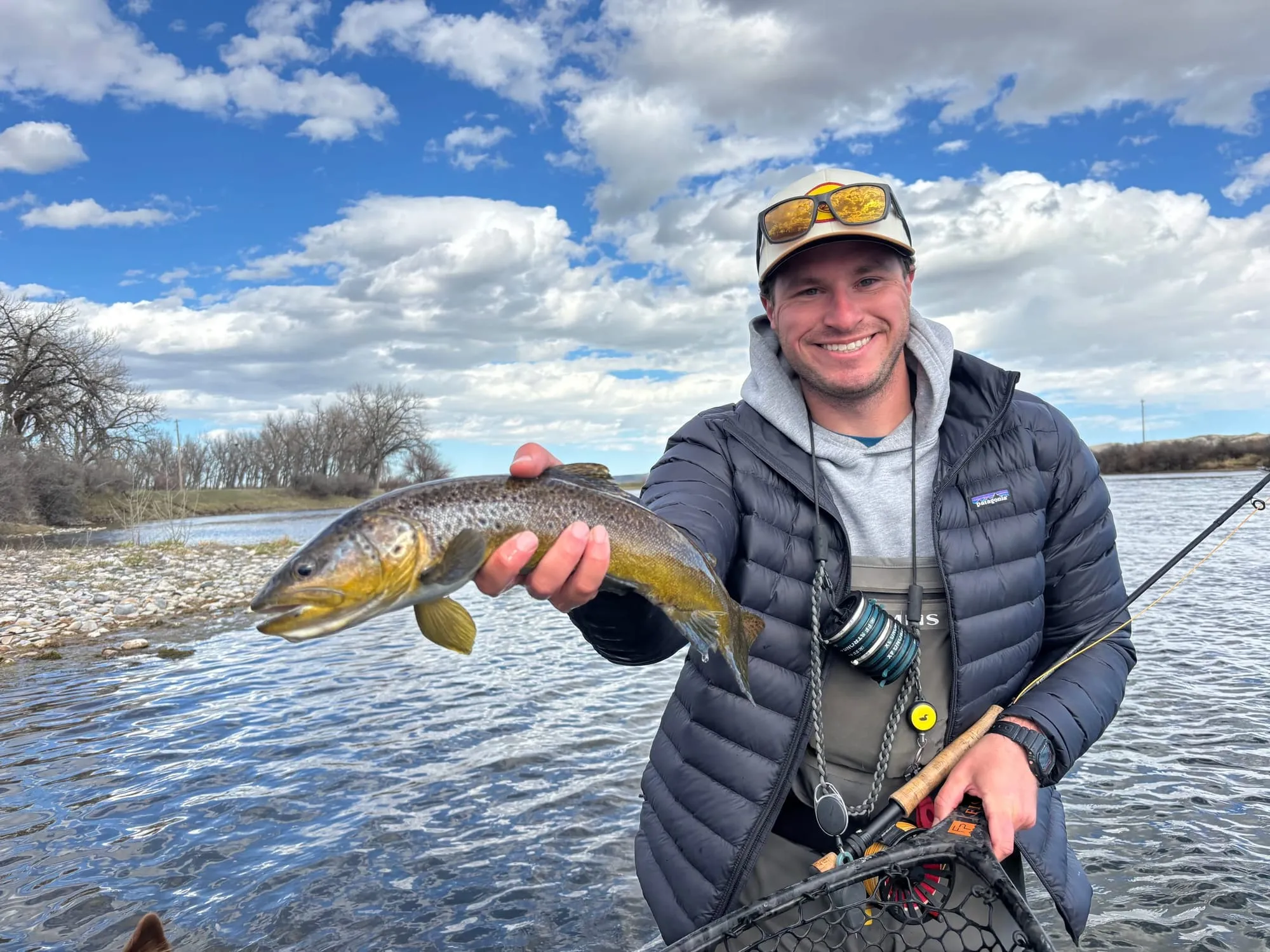 Holding up a brown trout on the gravel bar