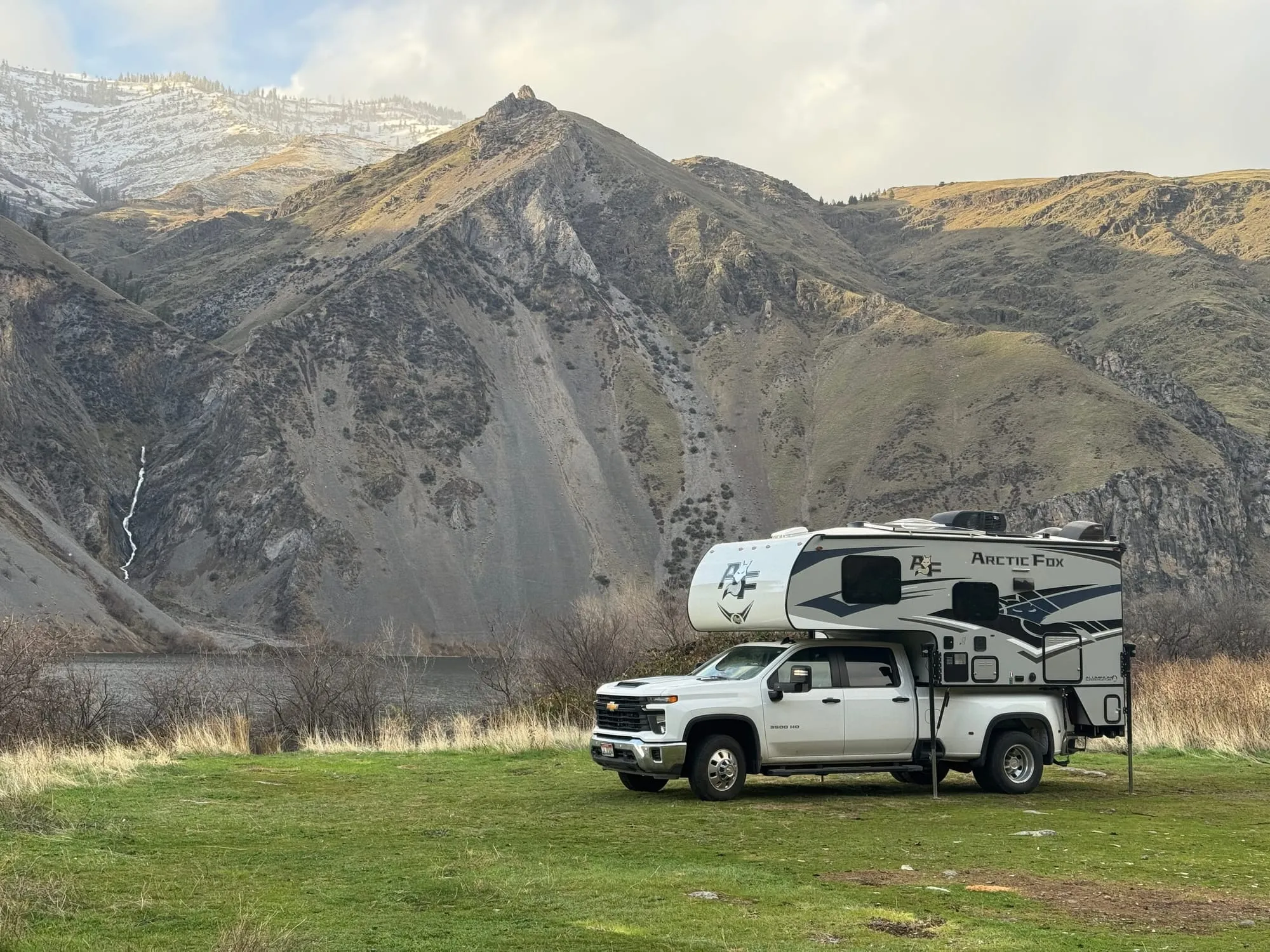 Camp beneath a snow-dusted mountain